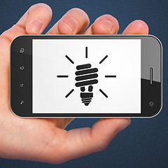 Image showing Finance concept: smartphone with Energy Saving Lamp.