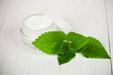 Image showing face cream in glass jar with green leaf of urtica