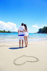 Image showing romantic  couple in love  have fun on the beach with heart drawi