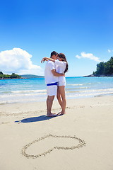 Image showing romantic  couple in love  have fun on the beach with heart drawi