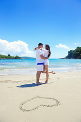 Image showing romantic  couple in love  have fun on the beach with heart drawi