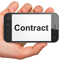 Image showing Hand holding smartphone with word Contract on display. Generic m