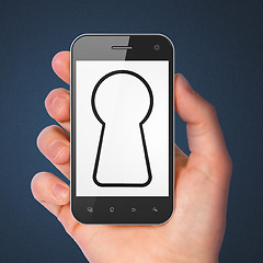 Image showing Hand holding smartphone with keyhole on display.