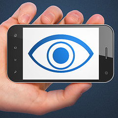 Image showing Hand holding smartphone with eye on display.
