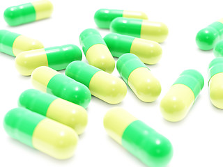 Image showing Many green-yellow pills on white