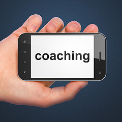 Image showing Hand holding smartphone with coaching on display