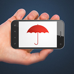 Image showing Hand holding smartphone with Umbrella on display