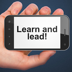 Image showing Hand holding smartphone with word Learn and lead