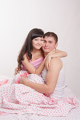 Image showing Newlyweds embracing sitting in bed