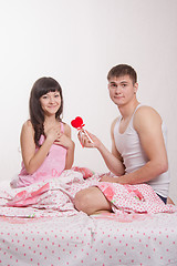 Image showing Young man gives heart beautiful girl in bed