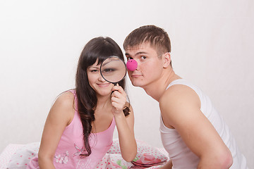 Image showing Girl with magnifying glass, guy clown nose