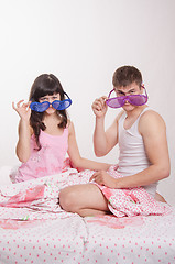 Image showing Young couple sitting in bed with big glasses