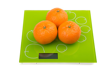 Image showing Three sweet mandarin on scales