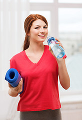 Image showing smiling girl with bottle of water after exercising