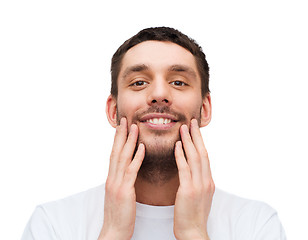 Image showing beautiful smiling man touching his face