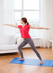 Image showing smiling teenage girl streching at home