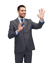 Image showing businessman working with imaginary virtual screen