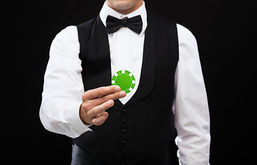 Image showing dealer holding green poker chip