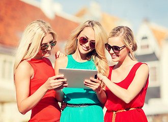 Image showing beautiful girls toursits looking into tablet pc