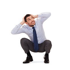 Image showing smiling businessman crouching on the floor