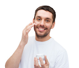 Image showing beautiful smiling man applyin cream
