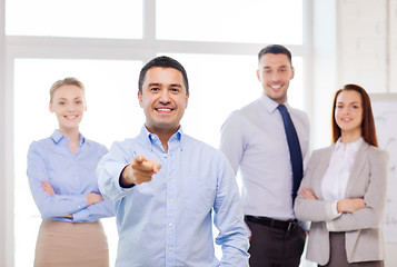 Image showing businessman in office pointing finger at you