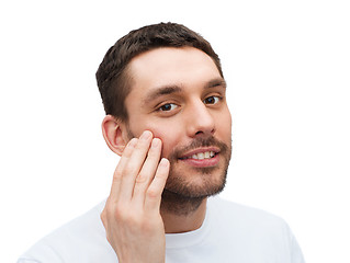 Image showing beautiful smiling man touching his face