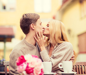 Image showing romantic happy couple kissing in the cafe