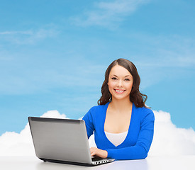 Image showing smiling woman in blue clothes with laptop computer