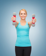 Image showing young sporty woman with light dumbbells