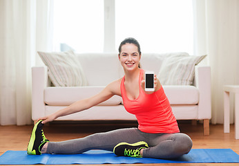 Image showing smiling teenage girl streching on floor at home