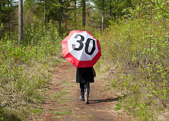 Image showing Woman in the forrest with a traffic sign umbrella