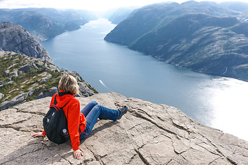 Image showing Woman sitting on Pulpit Rock / Preikestolen, Norway