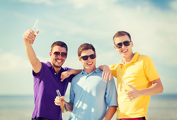 Image showing friends on the beach with bottles of drink