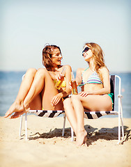 Image showing girls with drinks on the beach chairs