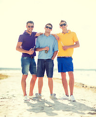 Image showing friends on the beach with bottles of drink