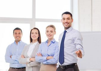 Image showing businessman in office pointing finger at you