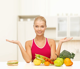 Image showing smiling woman with fruits and hamburger