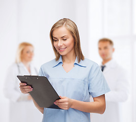 Image showing smiling female doctor or nurse with clipboard