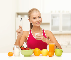 Image showing young woman eating healthy breakfast