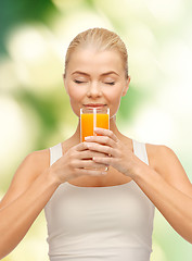 Image showing young woman drinking orange juice