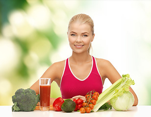 Image showing smiling young woman with organic food on the table