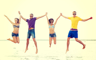 Image showing group of friends or couples jumping on the beach