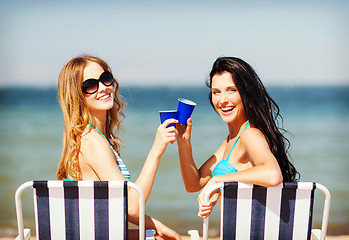 Image showing girls with drinks on the beach chairs