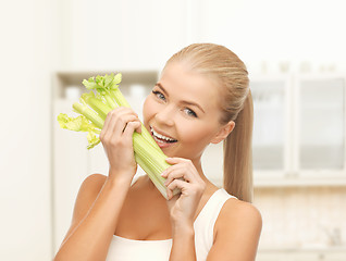 Image showing woman biting piece of celery or green salad