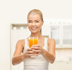 Image showing smiling woman holding glass of orange juice