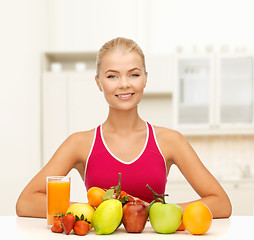 Image showing smiling woman with organic food or fruits on table