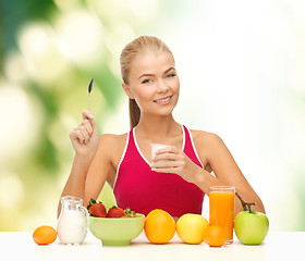 Image showing young woman eating healthy breakfast