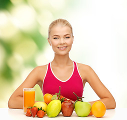 Image showing smiling woman with organic food or fruits on table