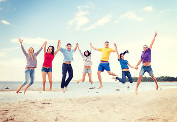 Image showing group of friends jumping on the beach